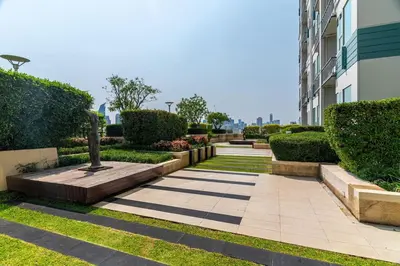 a garden with a statue in the middle of a building at Thonglor area 1 Bedroom FastWiFi Sauna Big Swimming Pool 38 in Bangkok