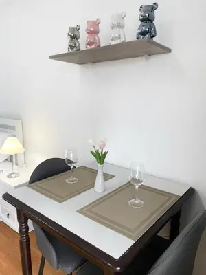 a table with two glasses and a vase with flowers on it at Apartment studio at platinum in Bangkok