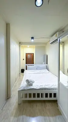a bedroom with a large white bed in it at Chubbi5 room11 in Bangkok