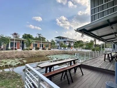 a deck with picnic tables and water lilies at Woodview Resort in Samut Prakan
