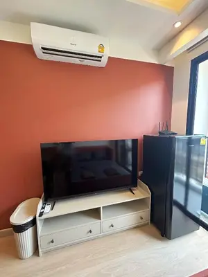 a living room with a flat screen tv on a wall at Brix26 in Bangkok