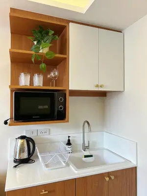 a kitchen with a sink and a microwave at Brix26 in Bangkok
