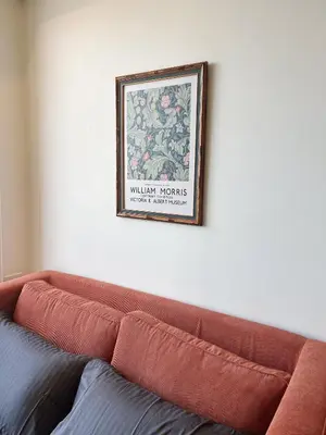 a picture hanging on a wall above a couch at Brix26 in Bangkok