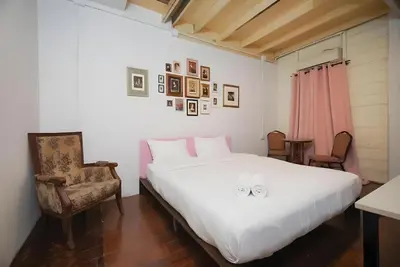a bedroom with a large white bed and a chair at XX Mitr Inn Yaowarat - China Town in Bangkok