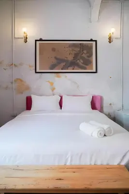 a bedroom with a white bed with a picture on the wall at XX Mitr Inn Yaowarat - China Town in Bangkok