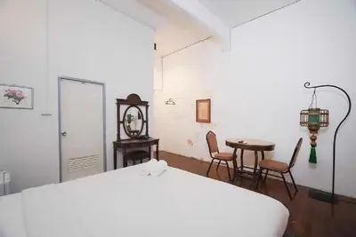 a bedroom with a bed and a table and chairs at XX Mitr Inn Yaowarat - China Town in Bangkok