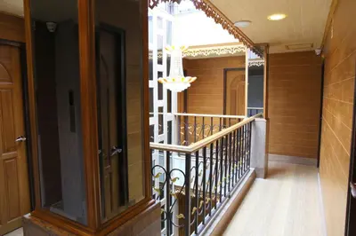 a hallway of a house with a staircase with a chandelier at Tanee Place in Bangkok
