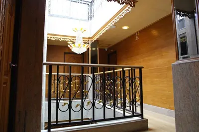 a hallway with a wrought iron railing and a chandelier at Tanee Place in Bangkok