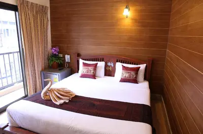 a bedroom with a bed with white sheets and red pillows at Tanee Place in Bangkok