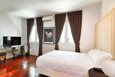 a hotel room with a bed and a television at Townhome 3 bed4 Baht Asok MRTBTS Sukhumvit 16 in Bangkok
