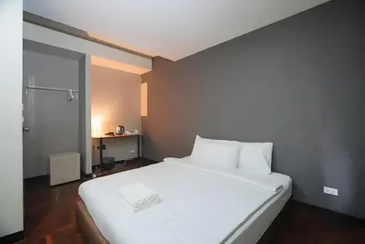 a large white bed in a small room at XX GO INN Silom - BTS Saint Louis สีลม in Bangkok
