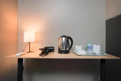 a coffee pot sitting on a table with a lamp at XX GO INN Silom - BTS Saint Louis สีลม in Bangkok