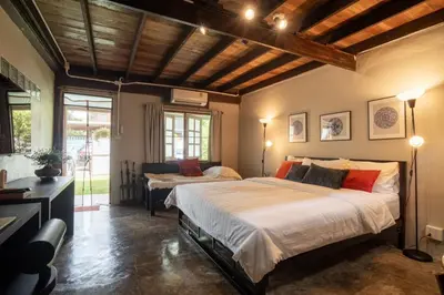 a large bedroom with a large bed and a table at Baan Apak Wat Arun in Bangkok Noi
