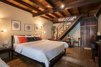 a bedroom with a large bed and a staircase at Baan Apak Wat Arun in Bangkok Noi
