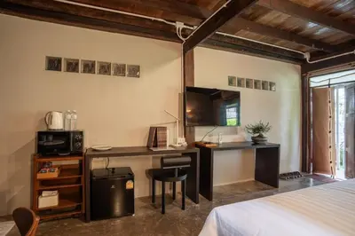 a bedroom with a desk with a computer and a bed at Baan Apak Wat Arun in Bangkok Noi