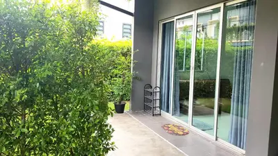 a sliding glass door of a house with a plant at Nido house in Ban Bang Phang