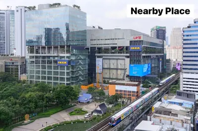 a train in a city with tall buildings at Whole Floor Penthouse, 3 Bedroom 3 Bath, Next to Metro Station in Bangkok