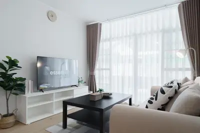 a living room with a couch and a tv and a table at Huai Khwang Cozy Home Comforts in Bangkok