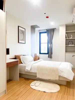 a bedroom with a bed and a desk and a window at The Gallery Bearing in Samut Prakan