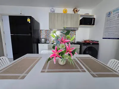 a kitchen with a table with pink flowers on it at Thaiphil Condo in Nonthaburi