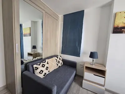 a small living room with a couch and a mirror at Thaiphil Condo in Nonthaburi