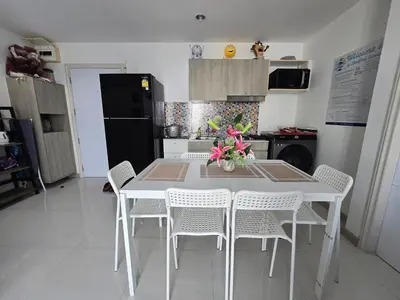 a kitchen with a white table and white chairs at Thaiphil Condo in Nonthaburi
