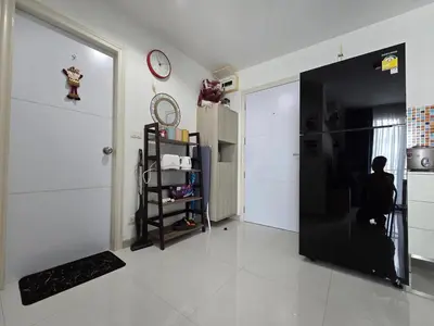 a room with a black door and a person sitting on a stool at Thaiphil Condo in Nonthaburi