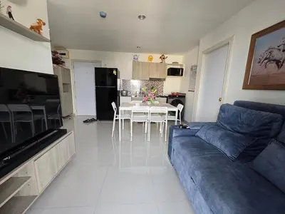 a living room with a blue couch and a table at Thaiphil Condo in Nonthaburi