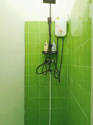 a green tiled bathroom with a hair dryer and a shower at Regalohome Bkk in Bangkok