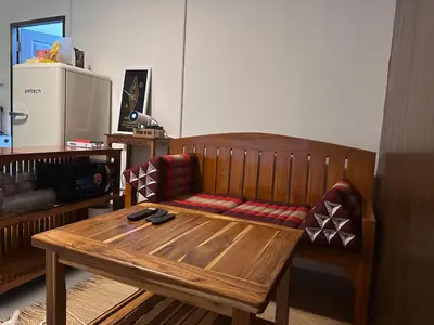 a wooden bench with a chair and a table at Regalohome Bkk in Bangkok