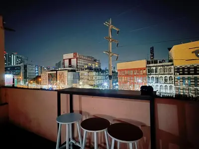 a bar with two stools and a view of a city at Regalohome Bkk in Bangkok