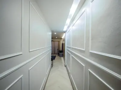 a hallway with white walls and a door at Oliver's House KS in Ban Yang