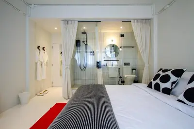 a bedroom with a large bed and a shower at Dear Sunday Hometel Bangkok in Bangkok