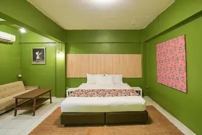 a green bedroom with a bed and a couch at XX GO INN The Grand Palace I โกอินน์ พระบรมมหาราชวัง สถานี MRT สามยอด in Bangkok