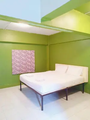 a bed in a room with a green wall at XX GO INN The Grand Palace I โกอินน์ พระบรมมหาราชวัง สถานี MRT สามยอด in Bangkok
