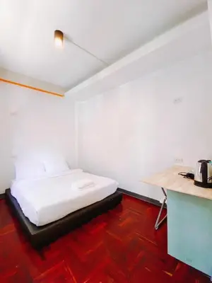 a white room with a bed and a table at GO INN Silom BTS Surasak สถานีสุรศักดิ์ in Bangkok