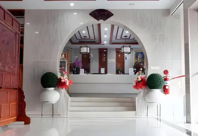 a lobby with an entry way with two white chairs with flowers at Palette The Travellers Hotel Bangkok in Bangkok