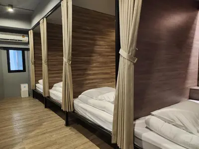 two bunk beds in a room with wooden floors at Fellows House in Bangkok