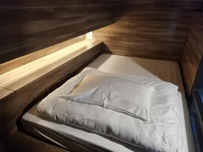 a small bed with a white pillow on it at Fellows House in Bangkok