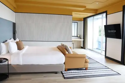 a hotel room with a bed and a chair at The Quarter Saphankhwai by UHG in Bangkok