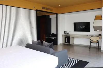 a bedroom with a bed and a desk with a television at The Quarter Saphankhwai by UHG in Bangkok