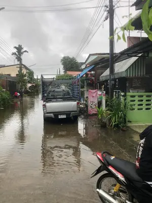 a truck is parked in a flooded street at ประเทศไทย in Ban Bang Krang