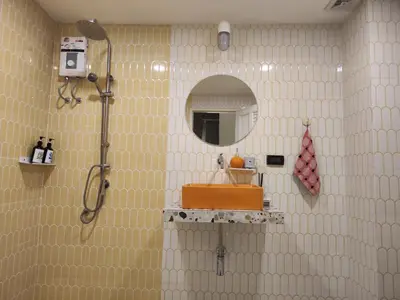 a bathroom with a shower and a sink and a mirror at Retrovibes Sathorn BTS ICONSIAM Asiatique Chao Phraya in Bangkok