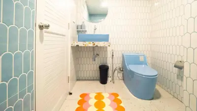 a bathroom with a blue toilet in a room at Retrovibes Sathorn BTS ICONSIAM Asiatique Chao Phraya in Bangkok