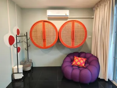 a purple chair with a pillow in a room at Retrovibes Sathorn BTS ICONSIAM Asiatique Chao Phraya in Bangkok