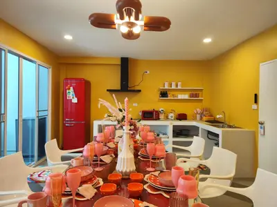 a dining room with a table and chairs and a red refrigerator at Retrovibes Sathorn BTS ICONSIAM Asiatique Chao Phraya in Bangkok
