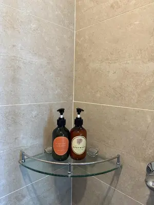 two bottles of soap sitting on a shelf in a bathroom at Regal 40 Srinakarin Apartment in Bangkok