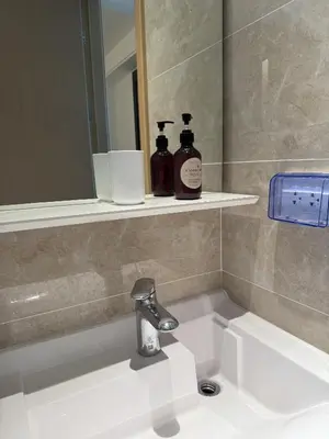 a bathroom sink with two bottles of soap and a mirror at Regal 40 Srinakarin Apartment in Bangkok
