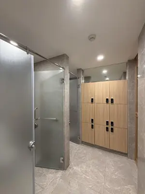 a locker room with wooden cabinets and a shower at Regal 40 Srinakarin Apartment in Bangkok