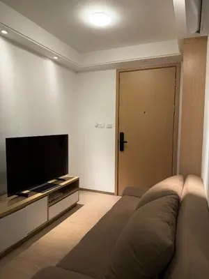a living room with a couch and a flat screen tv at Regal 40 Srinakarin Apartment in Bangkok